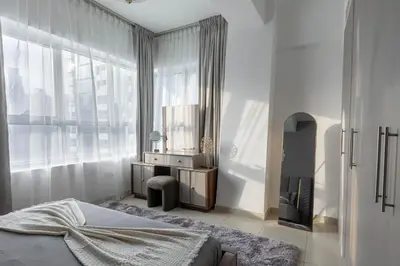 a bedroom with a bed and a desk and a window at Handsome 1BR in Armada Tower 3 in Dubai