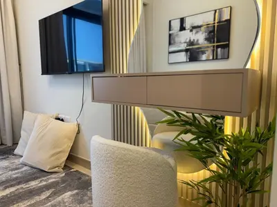a living room with a television and two chairs at Ashri Elegant Studio Near Burj Khalifa in Dubai