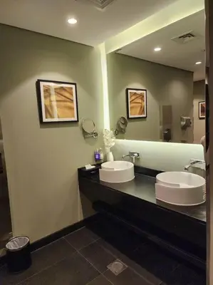 a bathroom with two sinks and a large mirror at Studio with Terrace Damac Maison Cour Jardin Business Bay in Dubai