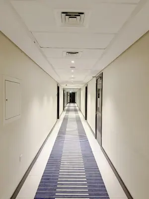 an empty corridor of an office building with a blue carpet at Studio with Terrace Damac Maison Cour Jardin Business Bay in Dubai