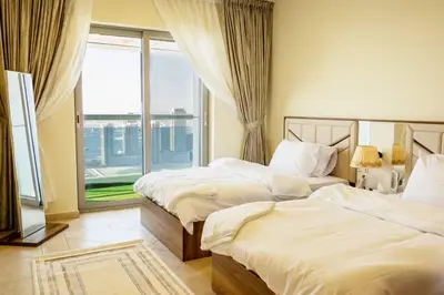 two beds in a room with a large window at Lux two br w Sea Views from rooms in Dubai Marina in Dubai
