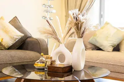 a living room with three vases on a coffee table at Lux two br w Sea Views from rooms in Dubai Marina in Dubai