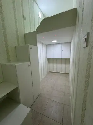 an empty room with a kitchen with a refrigerator at Loft bed short and long stay in Dubai