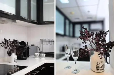 a kitchen with two wine glasses and a vase with flowers at Ultra-Chic 1BR Near Marina & Beach Walk in Dubai