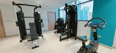 a gym with several tread machines in a room at Elegant Studio Apartment In Meydan One in Dubai
