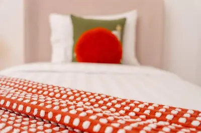 a red apple sitting on top of a bed at Prime retreats - steps to Grosvenor Hotel in Dubai