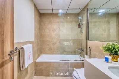 a bathroom with a tub and a toilet and a sink at 2BR Apt in Business Bay with Iconic Burj Khalifa and Dubai Canal Views in Dubai