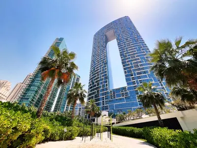 a tall building with palm trees in front of it at Address JBR, Beach View, Jumeirah Beach Residence - Mint Stay in Dubai