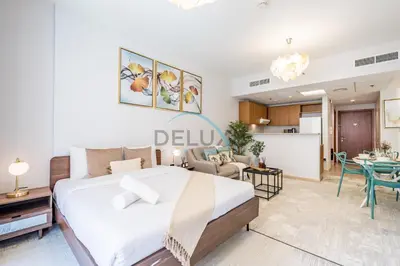 a bedroom with a bed and a living room at Contemporary Studio in Manara 6, Jebel Ali by Deluxe Holiday Homes in Dubai