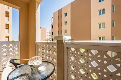 a table on a balcony with a view of buildings at Contemporary Studio in Manara 6, Jebel Ali by Deluxe Holiday Homes in Dubai