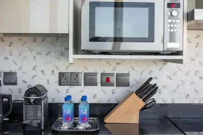 a kitchen counter with two bottles of water and a microwave at GLOBALSTAY Palm View in Dubai