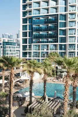 a resort with palm trees and a large building at DAMAC MAISON PRIVE - Lake View in Dubai