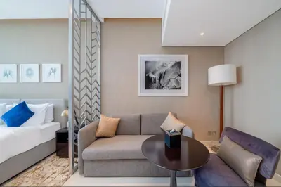 a hotel room with a couch and a bed at DAMAC MAISON PRIVE - Lake View in Dubai