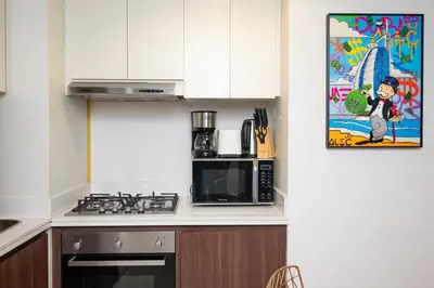 a kitchen with a stove top oven next to a microwave at Luxury Haven 2BR I Damac Vera I City Views in Dubai