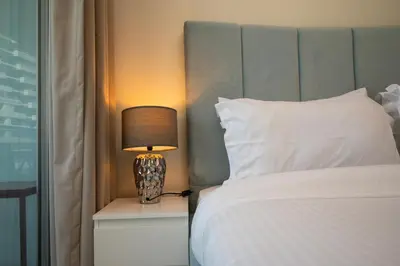 a bedroom with a bed and a lamp on a night stand at Luxury Haven 2BR I Damac Vera I City Views in Dubai