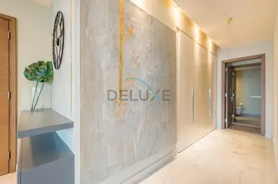a hallway with a wall with a sign that reads deluce at Radiant 2BR with Assistant Room at Citywalk Residential Building 7, Al Wasl by Deluxe Holiday Homes in Dubai