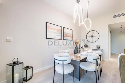 a dining room with a table and white chairs at Luxurious 2BR Apartment at Sadaf 6, Jumeirah Beach Residence by Deluxe Holiday Homes in Dubai