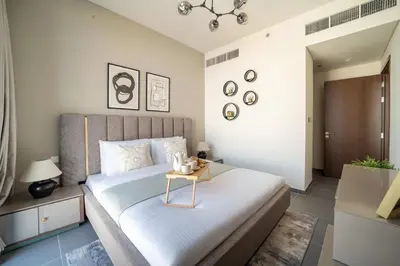 a bedroom with a bed with a table on it at Frank Porter - Creek Edge Tower 1 in Dubai