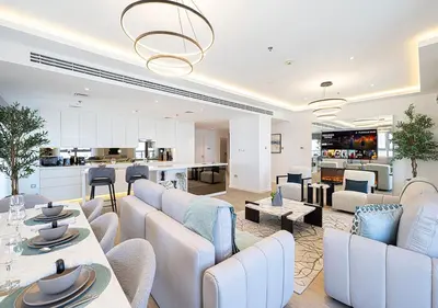 a living room with white furniture and a kitchen at Princess Tower - Spectacular Sky Views, Palm Jumeirah & JBR Beach in Dubai