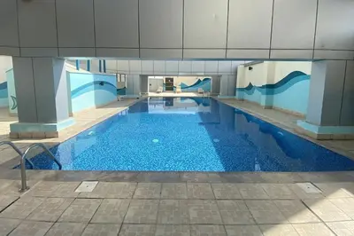 a large swimming pool with blue water in a building at Renovu Exclusive Residences in Dubai in Dubai