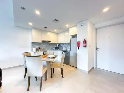 a kitchen and dining room with a table and chairs at Ultra Luxury Flat with Amazing Pool Near to Burj in Dubai