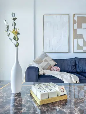 a living room with a blue couch and a vase at Ultra Luxury Flat with Amazing Pool Near to Burj in Dubai