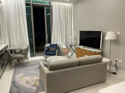 a living room with a couch and a flat screen tv at Infinity luxury in Dubai