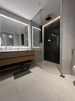 a bathroom with a glass shower and a sink at Infinity luxury in Dubai