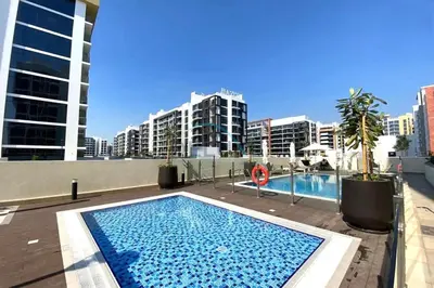 a swimming pool on top of a building with tall buildings at Cozy Studio in Azizi Riviera 44, Al Merkadh by Deluxe Holiday Homes in Dubai