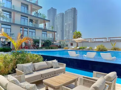 a swimming pool with a couch and chairs next to a building at Trendy Studio with top Amenities in Dubai