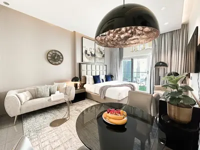 a living room with a bed and a table at Trophy Stays - Supreme Opulence - Chic Studio in Business Bay in Dubai