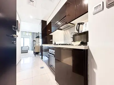 a kitchen with black cabinets and a white counter top at Trophy Stays - Supreme Opulence - Chic Studio in Business Bay in Dubai