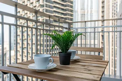 a wooden table with two cups and a potted plant on it at Burj Khalifa Views - 5 min walk from Dubai Mall - Upgraded - Designer Choice - 8 people - Dubai Opera in Dubai