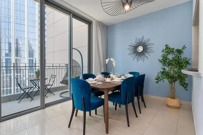 a dining room with a table and blue chairs at Burj Khalifa Views - 5 min walk from Dubai Mall - Upgraded - Designer Choice - 8 people - Dubai Opera in Dubai