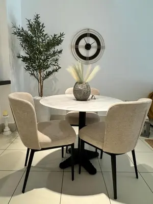 a white dining room table with chairs and a plant at Luxurious 1BR Aprt Burj Khalifa Area in Dubai