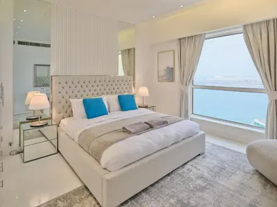 a bedroom with a large bed and a large window at JBR Beachfront Luxe apartment all Rooms Sea Facing in Dubai
