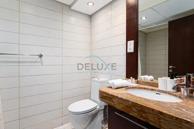 a bathroom with a toilet and a sink and a mirror at Chic Studio in Burj Views Podium, Downtown Dubai by Deluxe Holiday Homes in Dubai
