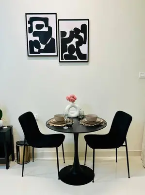 a table with two chairs and a vase on it at Lovely Studio in Damac Maison Cour Jardin Business Bay in Dubai