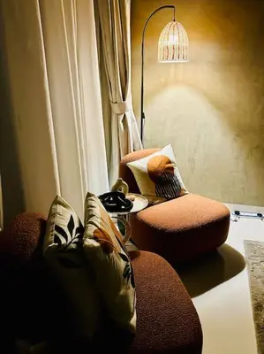 a living room with a couch and a lamp at Lovely Studio in Damac Maison Cour Jardin Business Bay in Dubai