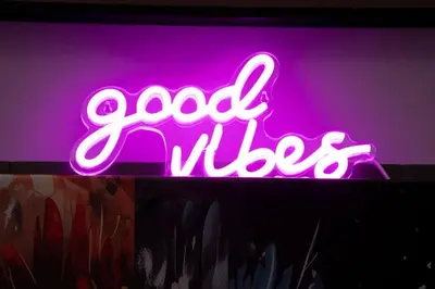 a neon sign that says good vibes on a wall at kinda Holiday Homes- Mag 318 Downtown in Dubai
