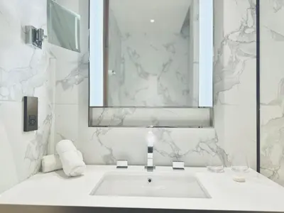 a white bathroom with a sink and a mirror at Skyline Retreat 3 Bedroom at Address Opera I Burj Khalifa & Fountain Views in Dubai