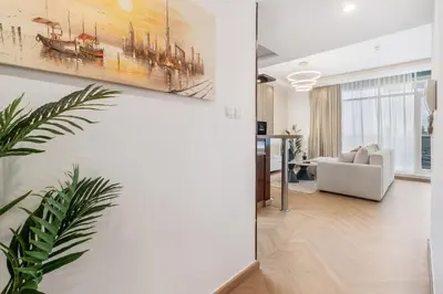 a living room with a couch and a painting on the wall at Elegant 3BR Lux Stay in the Heart of Dubai Marina in Dubai