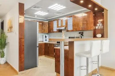 a kitchen with wooden cabinets and a counter top at Elegant 3BR Lux Stay in the Heart of Dubai Marina in Dubai