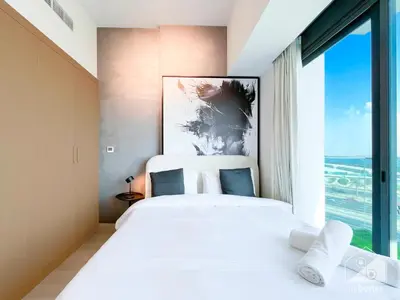 a bedroom with a large bed with a large window at Breath taking Studio with Balcony & Stunning Views in Dubai