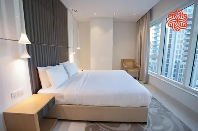 a bedroom with a large bed and a large window at Alashrafia Saray- Upscale 1bdr apartment in Canal Views in Dubai