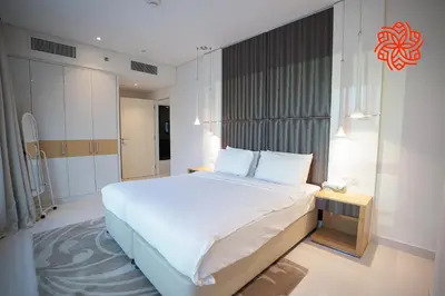 a bedroom with a large bed with white sheets and pillows at Alashrafia Saray- Upscale 1bdr apartment in Canal Views in Dubai