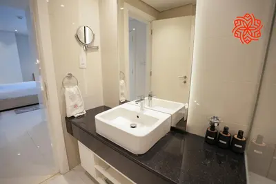 a bathroom with a white sink and a mirror at Alashrafia Saray- Upscale 1bdr apartment in Canal Views in Dubai