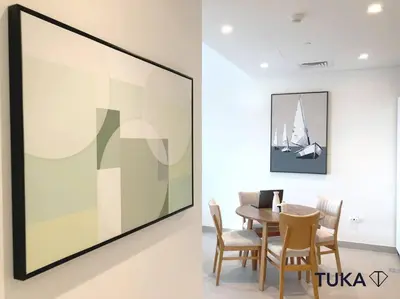a dining room with a table and a large painting at Stunning 2-BHK Golfville at Dubai Hills Prime in Dubai
