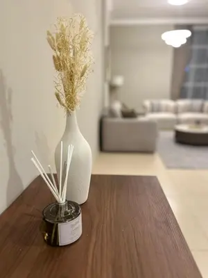a white vase sitting on a wooden table with flowers at 1BR in Mayfair tower Business bay! Burj views, close to Dubai mall in Dubai