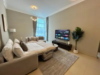 a living room with a couch and a flat screen tv at 1BR in Mayfair tower Business bay! Burj views, close to Dubai mall in Dubai